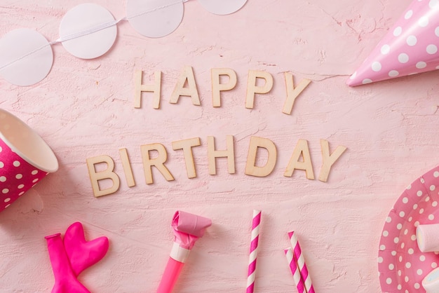 Geburtstagsfeier-Hintergrundgrenze von Konfetti-Bonbonlutschern und -geschenk auf rosa Oberflächenkopienraum-Draufsicht