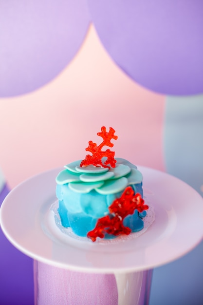 Geburtstagsfeier-Konzept. Tisch für Kinder mit Cupcakes mit blauer und roter Platte und Dekoartikeln in leuchtend blauen und violetten Farben. Sommersaison lecker auf der Party.