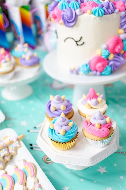 Geburtstagstisch für kleine Mädchen mit Einhornkuchen, Cupcakes und Zuckerplätzchen.