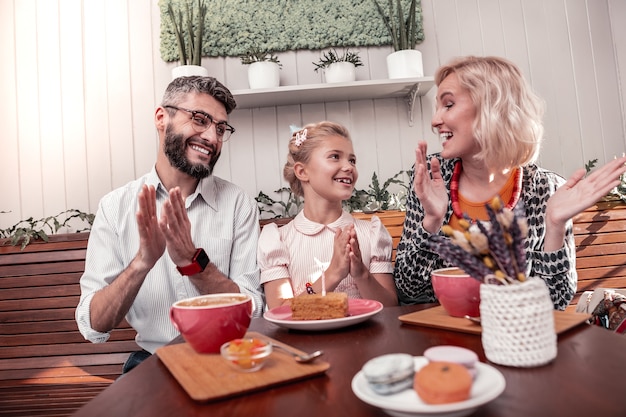 Geburtstagswünsche. positive freudige frau, die lächelt, während sie ihrer hübschen tochter gratuliert