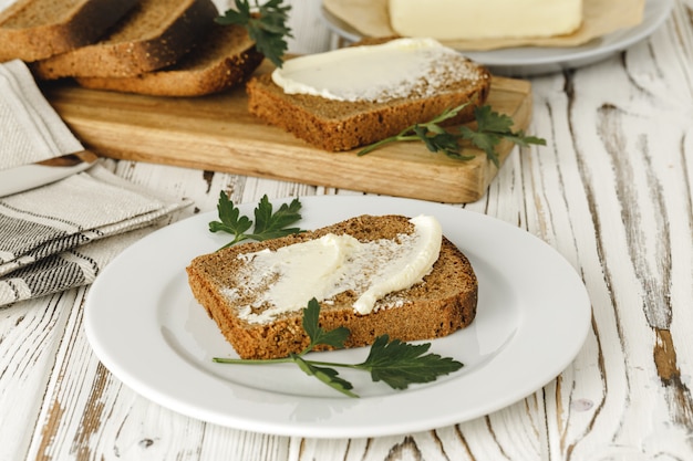 Gebutterte Scheibe Roggenbrot auf Holztisch