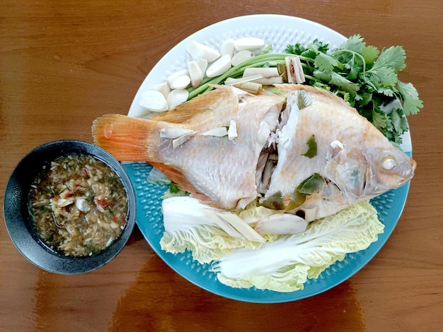 Foto gedämpfter fisch mit chili-limetten-saucethai traditionelles thailändisches essen im thailändischen stil gedünsteter fisch auf tischkl