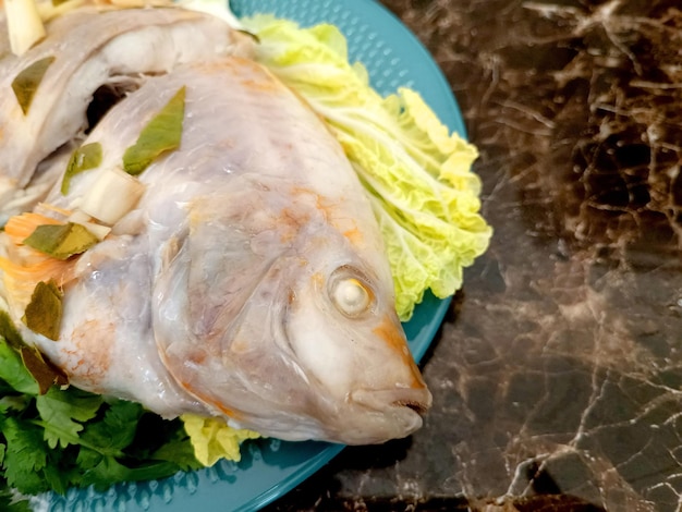 Foto gedämpfter fisch mit chili-limetten-saucethai traditionelles thailändisches essen thailändischer gedämpfter fisch auf tischkl