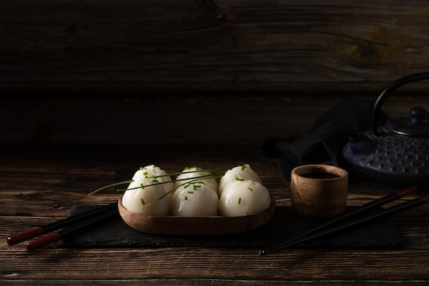 Gedämpftes Schweinefleisch und Garnelen-Dim Sum auf Schieferstein auf braunem Holztisch