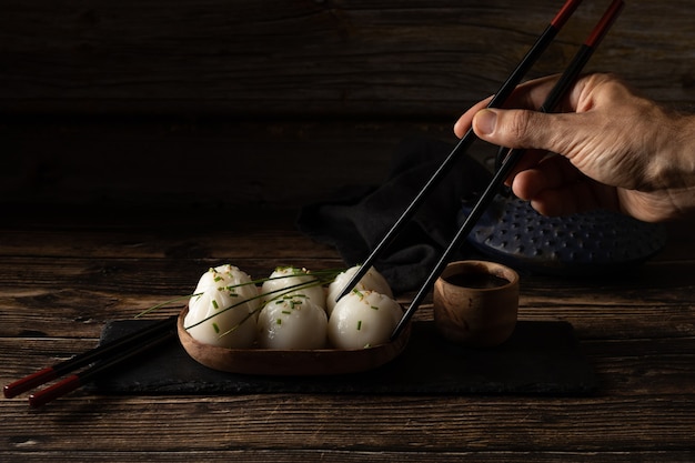 Gedämpftes Schweinefleisch und Garnelen-Dim Sum auf Schieferstein auf braunem Holztisch