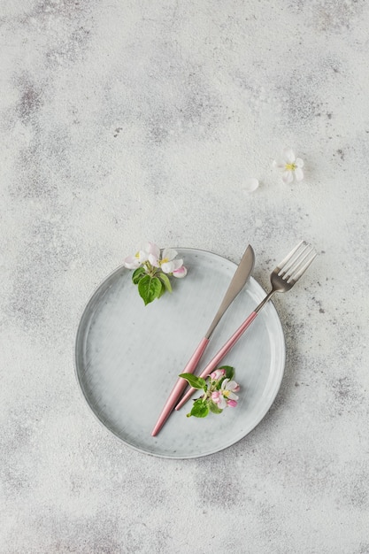 Gedeck mit blühenden Apfelbaumzweigen und Blumen