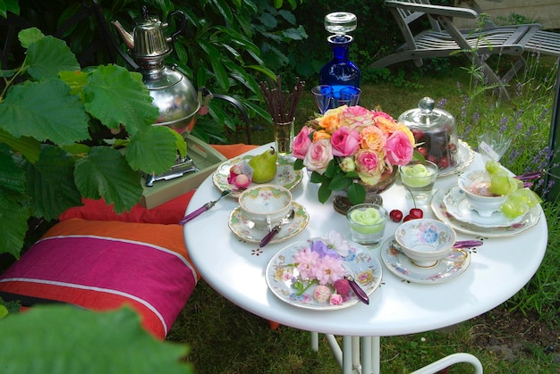 Gedeckter Tisch mit Porzellangeschirr und historischen Rosen rosa