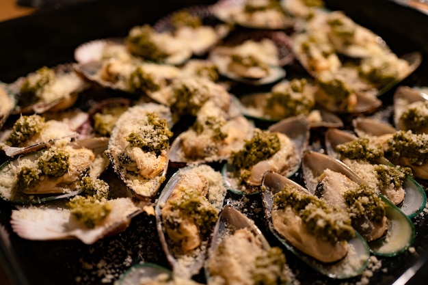 Gedimmtes Licht. Muscheln und Jakobsmuscheln in Muscheln werden beim Backen gekocht.