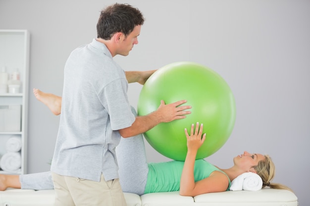 Geduldiges Training mit Übungsball und Physiotherapeuten