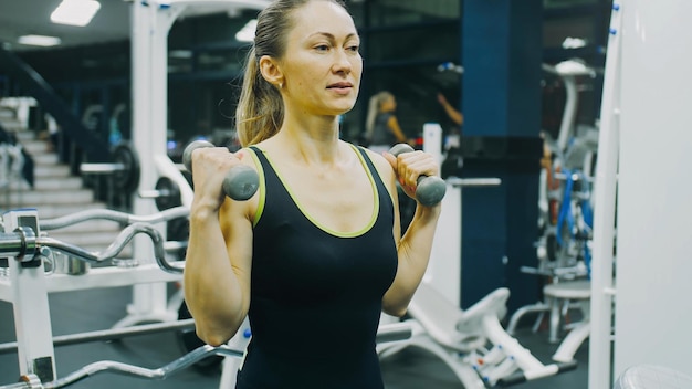 Geeignete athletische Frauenübungen mit Hantel. Bodypositives Mädchen mit schönen behaarten Achselhöhlen. Schweißgeruch.