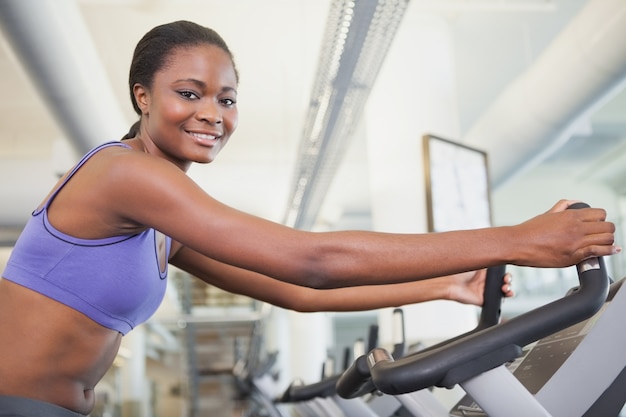 Geeignete Frau, die auf dem Hometrainer ausarbeitet