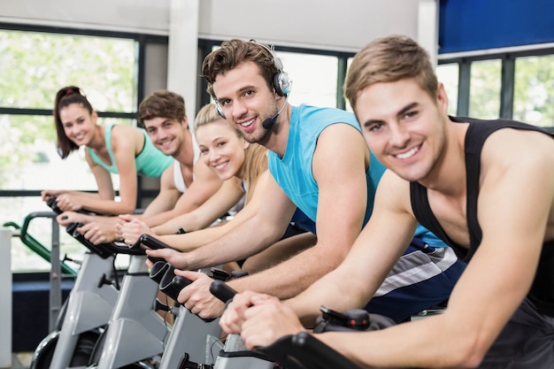 Geeignete Gruppe von Personen, die zusammen Hometrainer an der Turnhalle verwendet