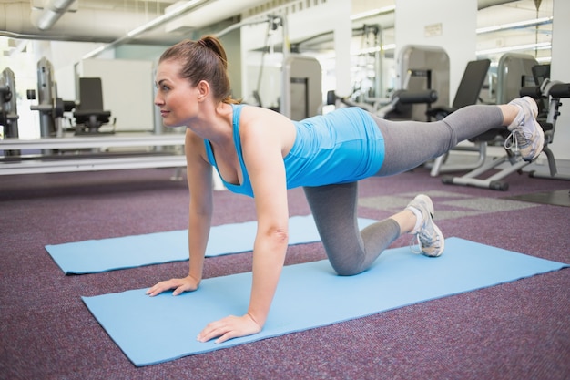 Geeigneter Brunette, der pilates auf Übungsmatte tut