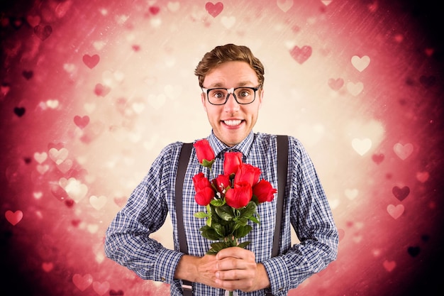 Foto geek hipster sosteniendo un ramo de rosas contra el diseño del corazón de san valentín