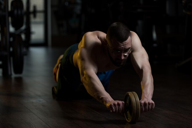 Geek man exercício com um ab roller