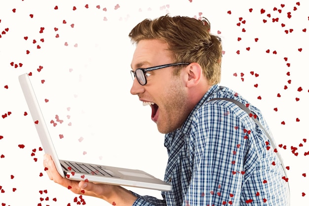 Geekiger Geschäftsmann, der seinen Laptop gegen rote Liebesherzen verwendet