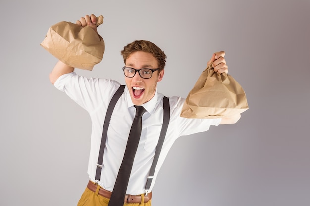 Geeky empresario sosteniendo bolsas de papel