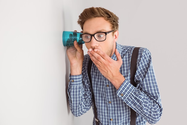 Geeky Geschäftsmann, der mit Cup heimlich zuhört