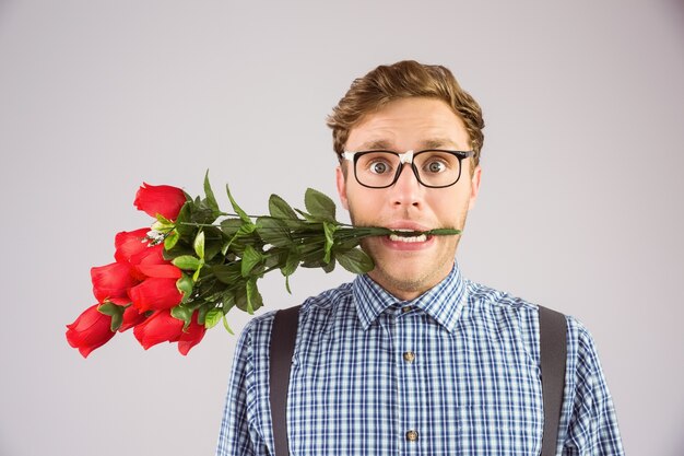 Geeky Hippie, der ein Bündel Rosen beißt