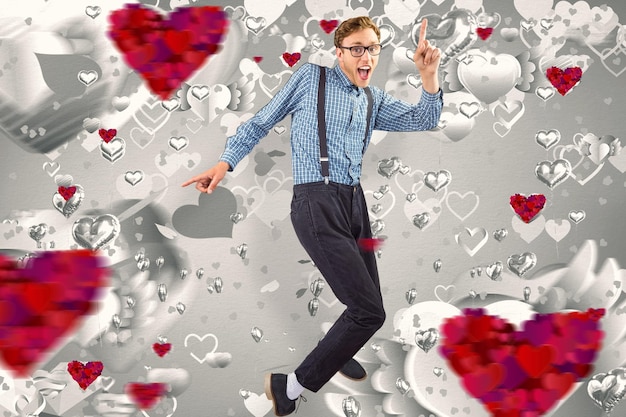 Geeky hipster bailando con vinilo contra el patrón de corazón gris de San Valentín