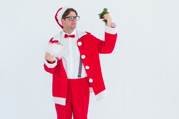 Geeky hipster no traje de Santa olhando o visco