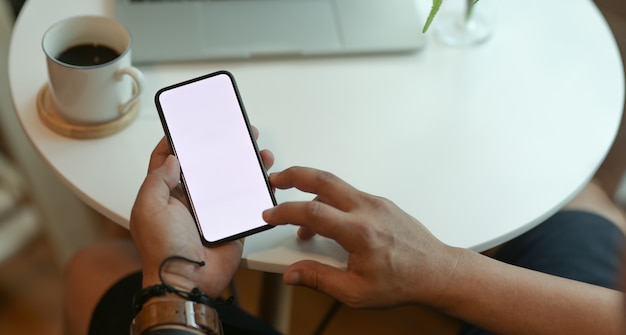 Geerntete Ansicht der Hände des Mannes, die Smartphone des leeren Bildschirms halten