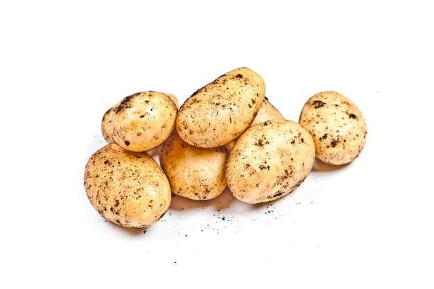 geernteter schmutziger Kartoffelhaufen lokalisiert auf Weiß