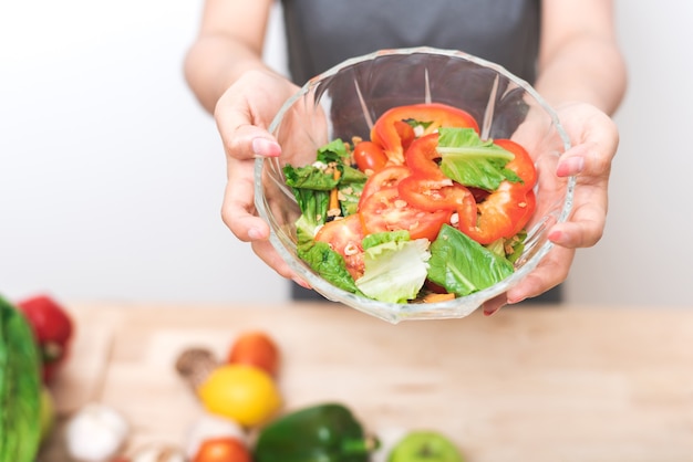 Geernteter Schuss der vegetarischen Salatschüssel der Frauenhand anwesenden