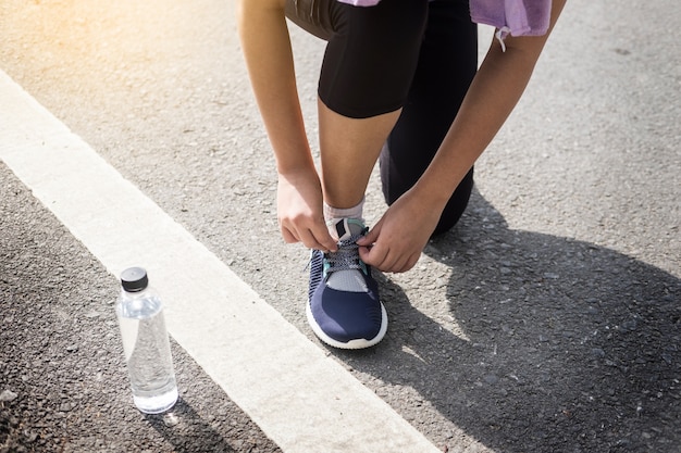 Geernteter Schuss des Laufs der jungen Frauen, der Laufschuh festzieht