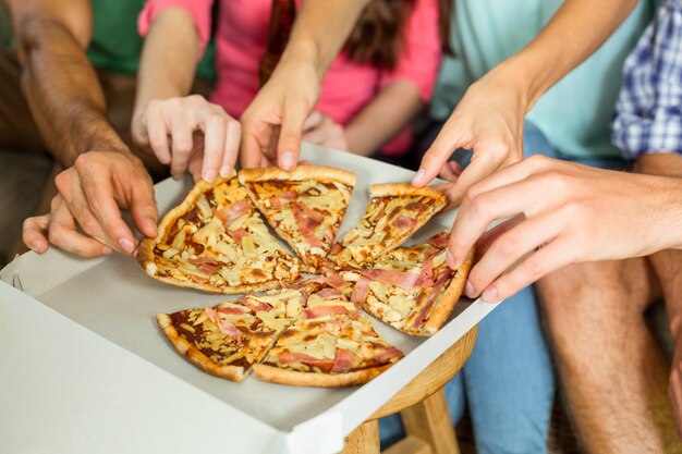 Geerntetes Bild von den Freunden, die Pizza essen