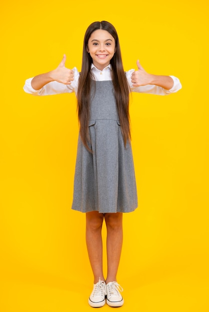 Gefällt mir Porträt eines fröhlichen Teenager-Mädchens, das Daumen hoch zeigt und gelben Hintergrund mit Kopierraum lächelt