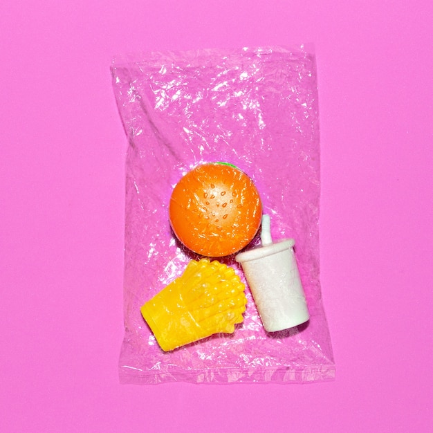 Gefälschtes Fastfood in einer Plastiktüte. Minimale flache Lay-Kunst