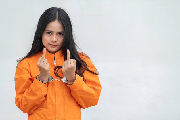 Gefangener im orangefarbenen GewandkonzeptPorträt einer asiatischen Frau in Gefängnisuniformen auf weißem Hintergrund