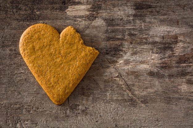 Geformtes Plätzchen des defekten Herzens auf Holztisch. Valentinstag- und Muttertagkonzept