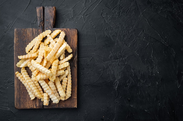 Gefrorene Crinkle-Ofen-Pommes auf Holzschneidebrett