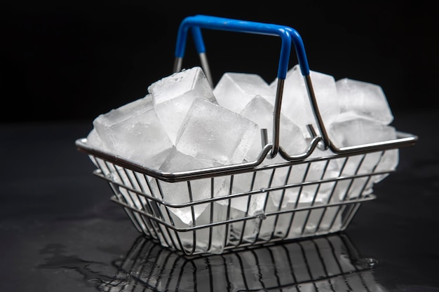 Gefrorene Eiswürfel in einem Einkaufskorb auf dunklem Hintergrund