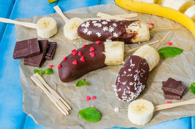 Gefrorene hausgemachte Bananenknalle mit Schokoladenglasur überzogen. Leckeres, diätetisches und gesundes Dessert.