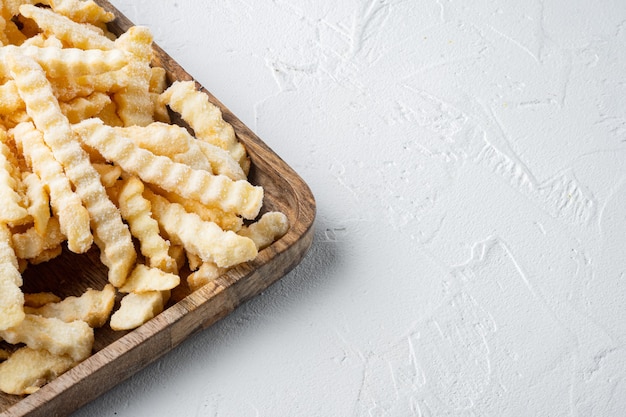 Gefrorene Pommes Frites Kartoffeln auf Holztablett gesetzt