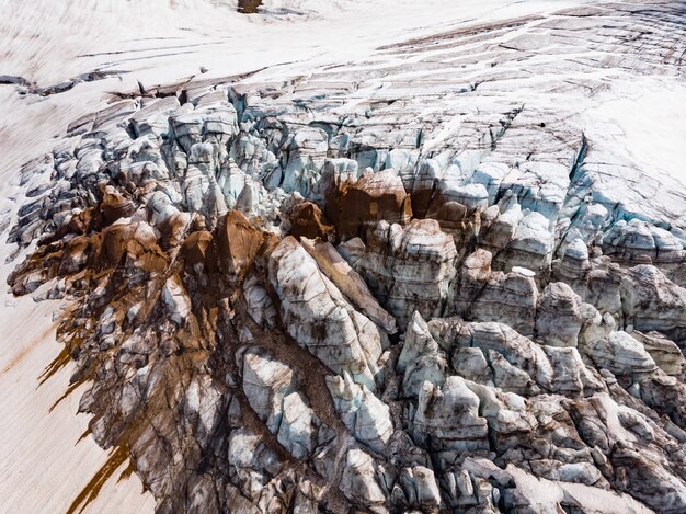 Gefrorene Sandformationen mit Schnee und Eis bedeckt auf einem Berggipfel, beleuchtet von einer hellen Sonne