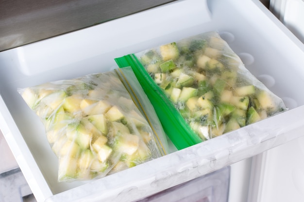 Gefrorene Zucchiniwürfel im Gefrierschrank. Tiefkühlkost-Konzept. Horizontal