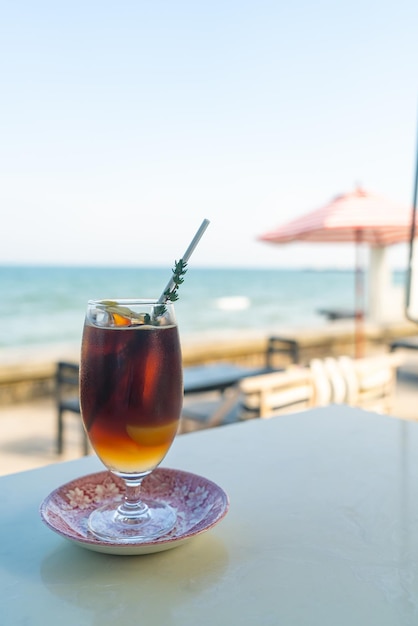 gefrorener americano-kaffeepfirsich mit ozeanmeerhintergrund