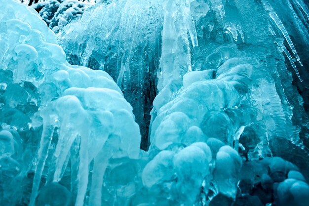 Gefrorener kleiner blauer Bergwasserfall nah oben