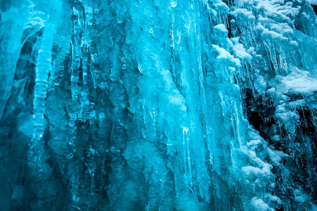 Gefrorener kleiner blauer Bergwasserfall nah oben