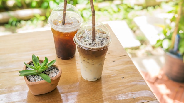 gefrorener Latte und americano Kaffee auf einem Holztisch.