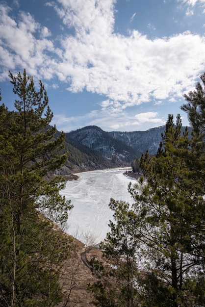 Gefrorener mana-fluss im winter und berge im hintergrund vertikales foto sibirische frühlingslandschaft