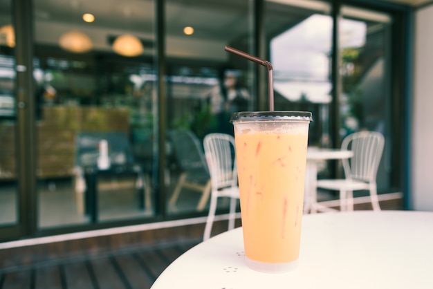 Gefrorener Milchtee mit Stroh in der Plastikschale auf einer Tabelle im Sommer, Weinlese