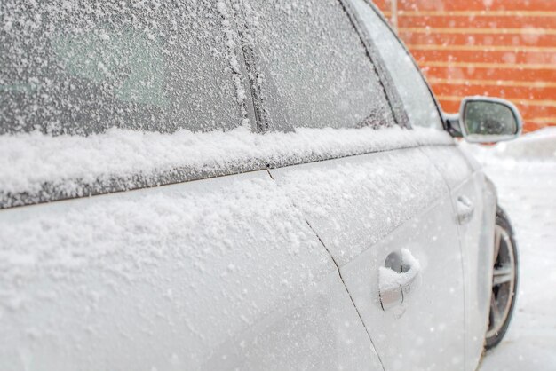 Gefrorener Rückspiegel, verschneites Auto. Winter, Schnee, Schneefall