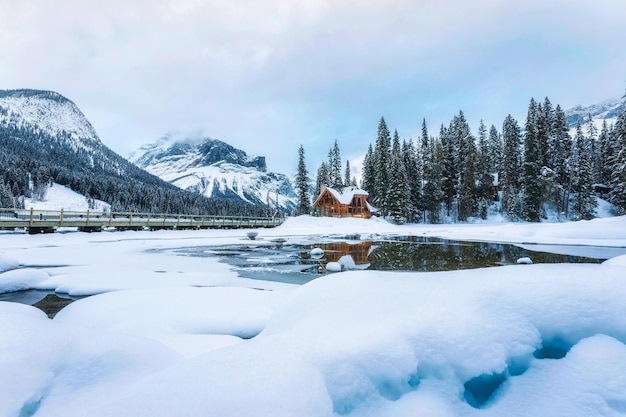 Gefrorener Smaragdsee mit Holzhütte im Pinienwald im Winter