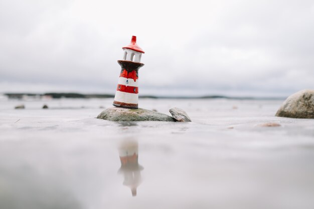 Gefrorenes Wintermeer mit dekorativem Leuchtturm. Winter, Meer, Reisen, Abenteuerkonzept.