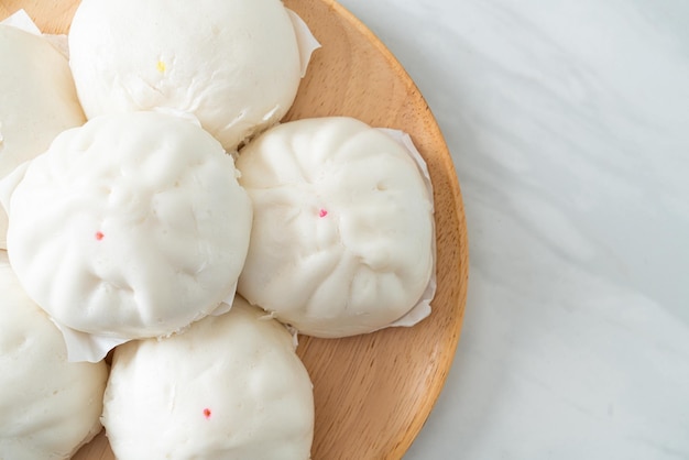 gefüllte gedämpfte Brötchen auf Holzplatte - chinesisches Essen